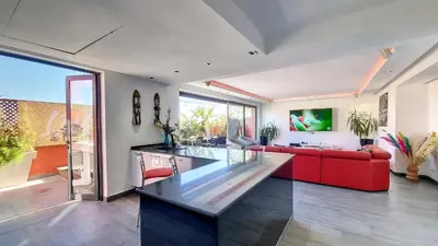 a living room with a red couch and a glass table at Exceptional View & Hot Tub Marrakesh in Marrakech