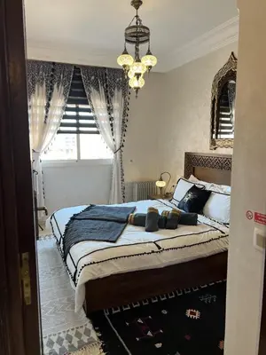 a bedroom with a large bed and a chandelier at Dar Mezhor apartment in Marrakech