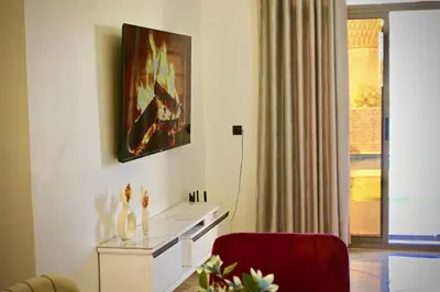 a living room with a table and a red chair at Villa El Ilham réservée aux familles in Marrakech