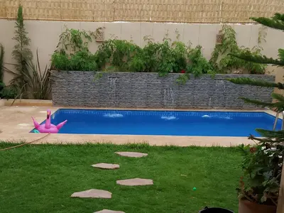 a swimming pool with a pink flamingo in the grass at Villa El Ilham réservée aux familles in Marrakech