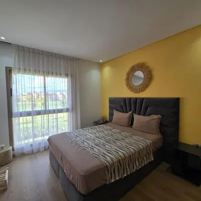 a bedroom with a large bed with a large window at Luxury Flat 2 Bedrooms Prestigia Golf City in Marrakech