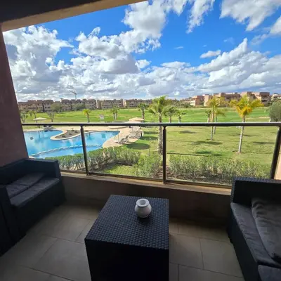 a room with a large window with a view of a pool at Luxury Flat 2 Bedrooms Prestigia Golf City in Marrakech