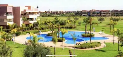 a resort with a swimming pool and palm trees at Luxury Flat 2 Bedrooms Prestigia Golf City in Marrakech