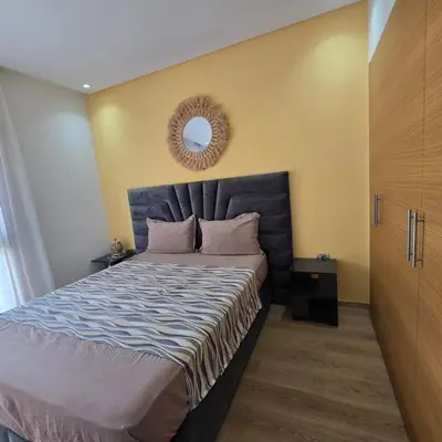 a bedroom with a large bed with a mirror on the wall at Luxury Flat 2 Bedrooms Prestigia Golf City in Marrakech