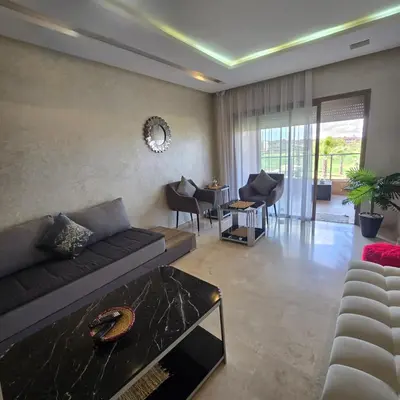a living room with a couch and a table at Luxury Flat 2 Bedrooms Prestigia Golf City in Marrakech