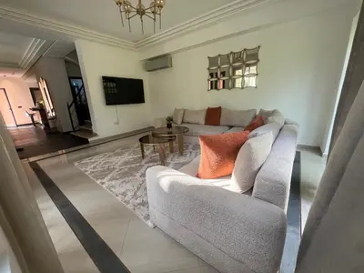 a living room with a couch and a tv at Villa palmeraie in Marrakech