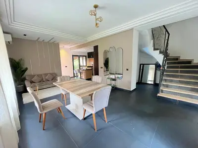 a dining room with a table and chairs and stairs at Villa palmeraie in Marrakech