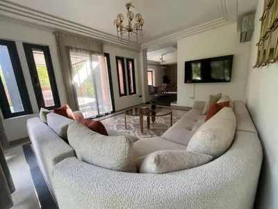 a living room with a white couch and a table at Villa palmeraie in Marrakech