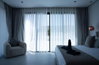 a bedroom with a bed and a chair and a window at Modern Villa Selma in Marrakech