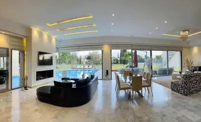 a living room with a couch and a dining room at Spacious Villa with Mountain Views - 550 m² in Marrakech