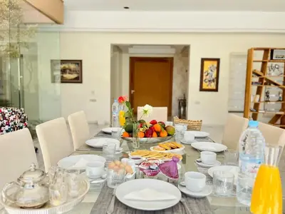 a table with plates and bowls of fruit on it at Spacious Villa with Mountain Views - 550 m² in Marrakech