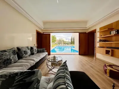 a living room with a couch and a swimming pool at Spacious Villa with Mountain Views - 550 m² in Marrakech