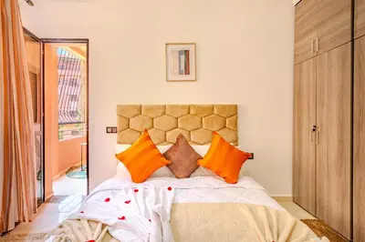 a bedroom with a large bed with orange pillows at Oasis de charme au cœur de Marrakech in Marrakech