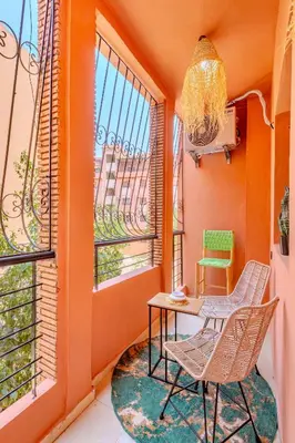 an orange room with a table and chairs on a balcony at Oasis de charme au cœur de Marrakech in Marrakech