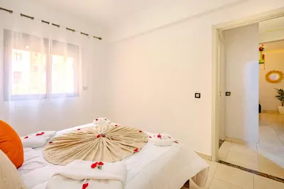 a white room with a bed with an umbrella on it at Oasis de charme au cœur de Marrakech in Marrakech