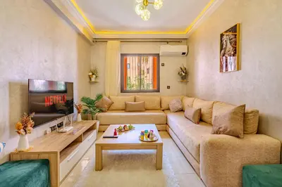a living room with a couch and a tv at Oasis de charme au cœur de Marrakech in Marrakech