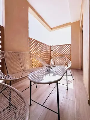 a room with a table and chairs on a balcony at Modernes Apartment in Top-Lage in Guéliz Marrakech in Marrakech