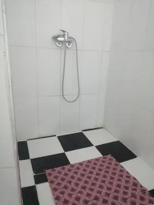a bathroom with a shower with a red rug on the floor at Grand appartement à 3 minutes de la place jamaa el fana in Marrakech