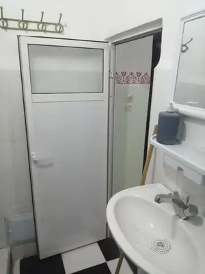 a white bathroom with a sink and a shower at Grand appartement à 3 minutes de la place jamaa el fana in Marrakech