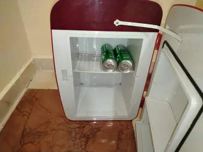 a small refrigerator with two green bottles in it at غرفة مريحة و نضيفة in Marrakech