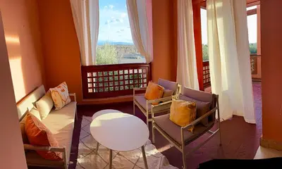 a living room with a couch and chairs and a window at appartement bel vue sur l'atlas in Marrakech