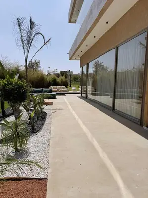 a walkway in front of a building with palm trees at Villa Maymouna in Marrakech