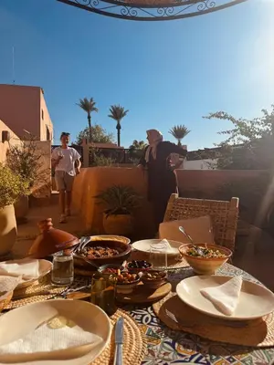 a table with plates and bowls of food on a patio at Momo House- Riad Momo in Marrakech
