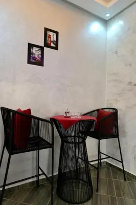 a red table and two chairs in a restaurant at good Appartement Marrakech in Marrakech