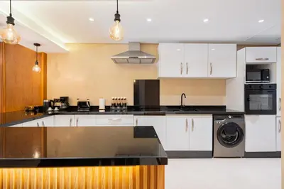 a kitchen with white cabinets and a dishwasher at M REVASION Elegant Luxury Stays in the Center of Marrakech in Marrakech