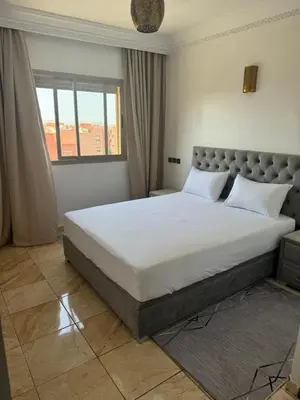 a bedroom with a large bed with white sheets at GHIZLAN Apartment in Marrakech
