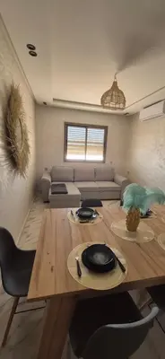 a living room with a table and a couch at Havre de paix en plein Marrakech in Marrakech
