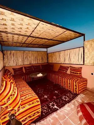 a room with two beds and a table at Riad Kimee Room 3 in Marrakech