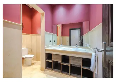 a bathroom with two sinks and a toilet at Villa Pivoine avec Jacuzzi, Cuisinière, Piscine in Marrakech