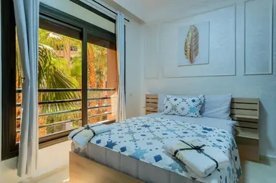 a bedroom with a bed and a large window at Charment et spacieux 2 chambres avec salon in Marrakech