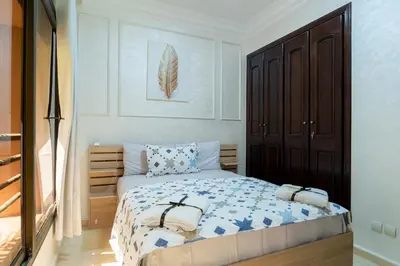 a bedroom with a bed with blue and white sheets at Charment et spacieux 2 chambres avec salon in Marrakech