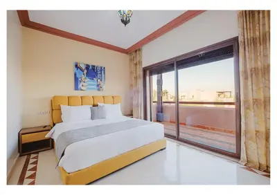 a bedroom with a large bed and a large window at Villa Magnolia avec Jacuzzi, Cuisinière, Piscine in Marrakech