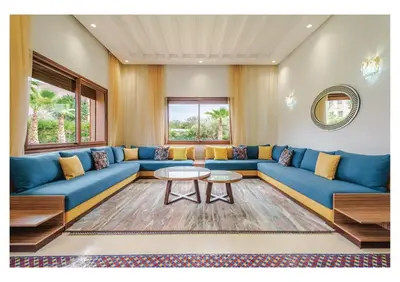a living room with a blue couch and a table at Villa Magnolia avec Jacuzzi, Cuisinière, Piscine in Marrakech