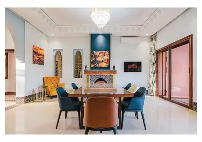 a dining room with a table and chairs and a fireplace at Villa Magnolia avec Jacuzzi, Cuisinière, Piscine in Marrakech
