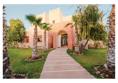 a walkway in front of a house with palm trees at Villa Magnolia avec Jacuzzi, Cuisinière, Piscine in Marrakech