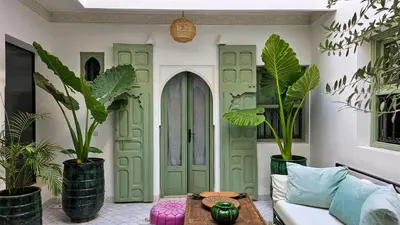 a living room with a green door and plants at Riad Akhdar Kasbah Breakfast included in Marrakech