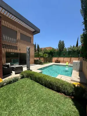 a swimming pool in the backyard of a house at Villa Résidence Akenza in El Rhechat