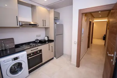 a kitchen with a refrigerator and a washer and dryer at Stylish Apartment Heart of Gueliz Netflix in Marrakech