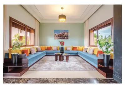 a living room with a blue couch and orange pillows at Villa Dahlia Jacuzzi, Stove, Pool in Marrakech
