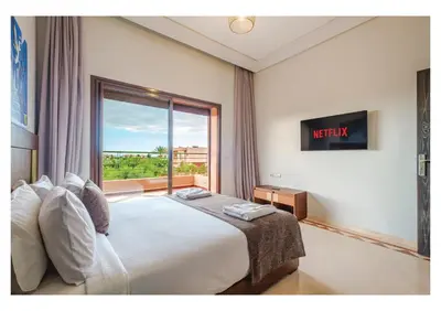 a bedroom with a bed and a large window at Villa Dahlia Jacuzzi, Stove, Pool in Marrakech