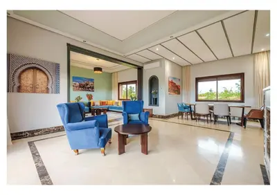 a living room with blue chairs and a table at Villa Dahlia Jacuzzi, Stove, Pool in Marrakech