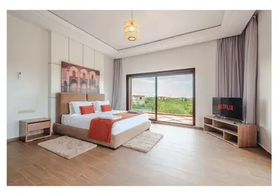 a bedroom with a large bed and a television at Villa Dahlia Jacuzzi, Stove, Pool in Marrakech
