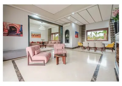 a living room with pink furniture and a dining room at VILLA Lavande Jacuzzi, Cuisinière, Piscine in Marrakech