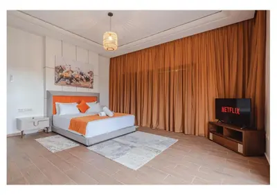 a bedroom with a bed and a tv in it at VILLA Lavande Jacuzzi, Cuisinière, Piscine in Marrakech