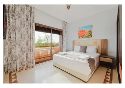 a bedroom with a large bed and a window at Villa Camelia avec Jacuzzi, Cuisinière, Piscine in Marrakech