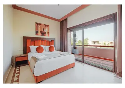 a bedroom with a large bed and a large window at Villa Camelia avec Jacuzzi, Cuisinière, Piscine in Marrakech